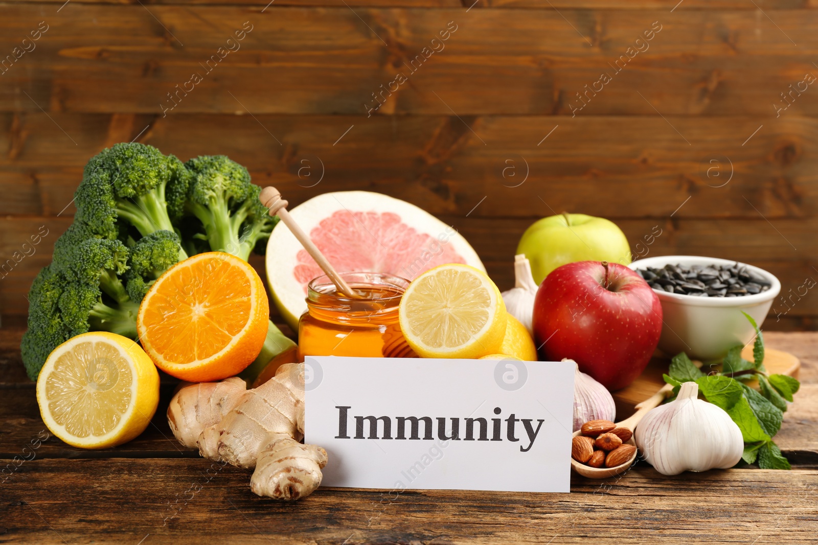 Photo of Card with word Immunity and fresh products on wooden table