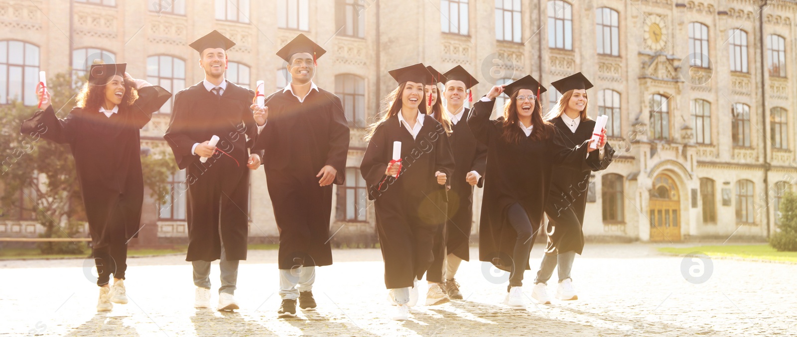 Image of Happy students with diplomas near campus. Banner design