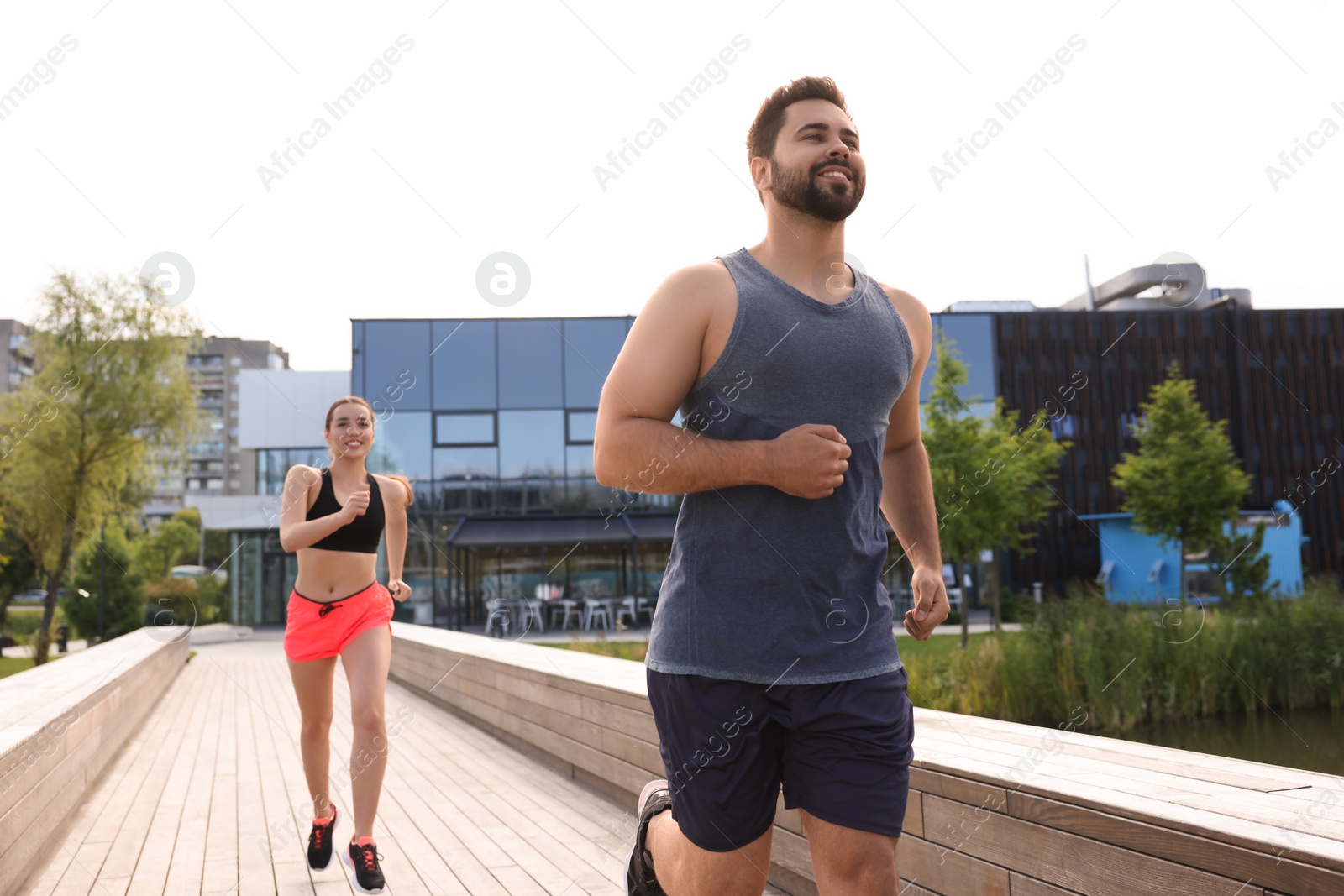 Photo of Healthy lifestyle. Happy couple running outdoors on sunny day