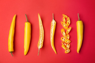 Flat lay composition with chili peppers on color background