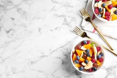 Photo of Fresh tasty fruit salad on white marble table, flat lay. Space for text