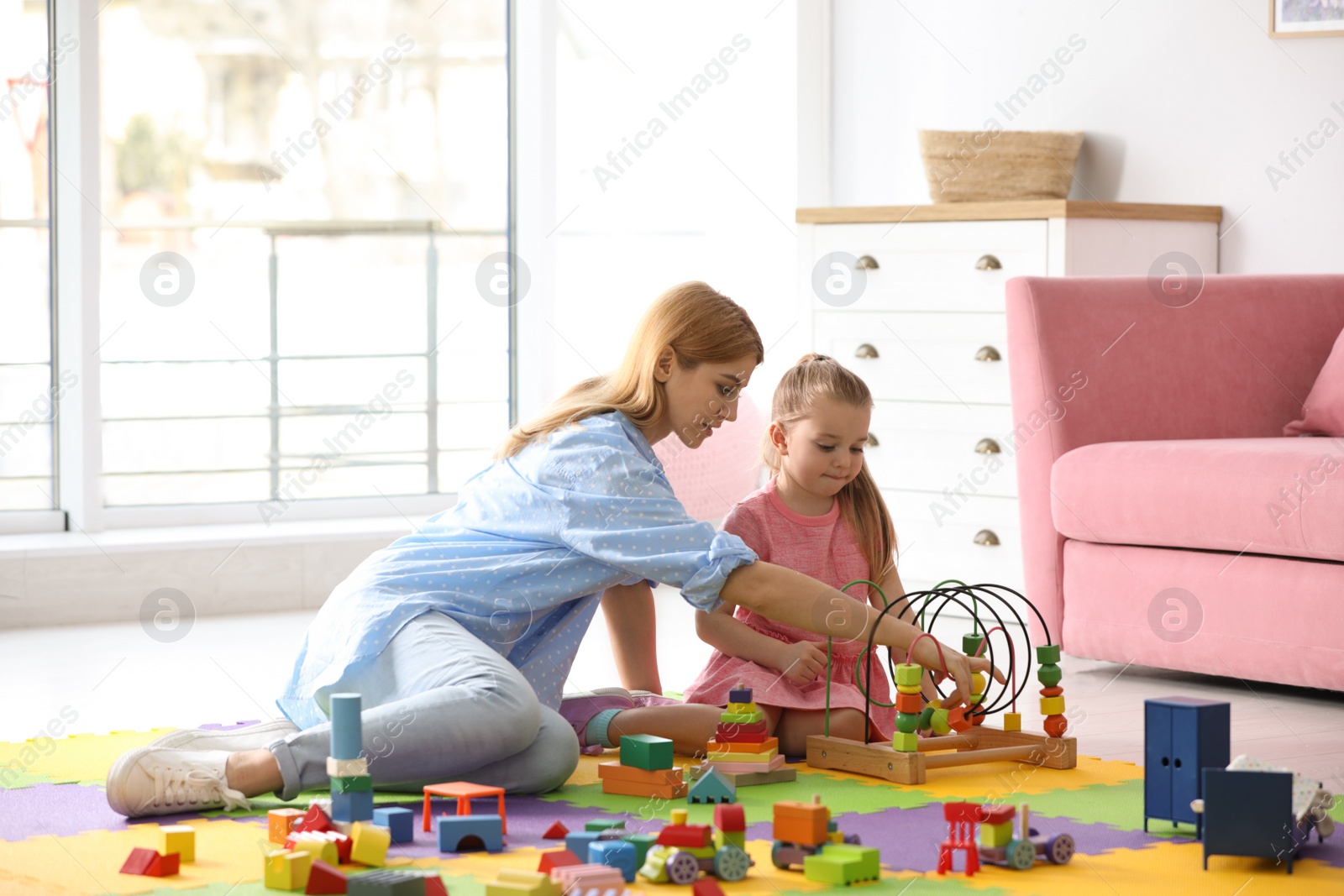 Photo of Mother playing with her child at home