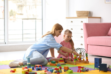 Photo of Mother playing with her child at home