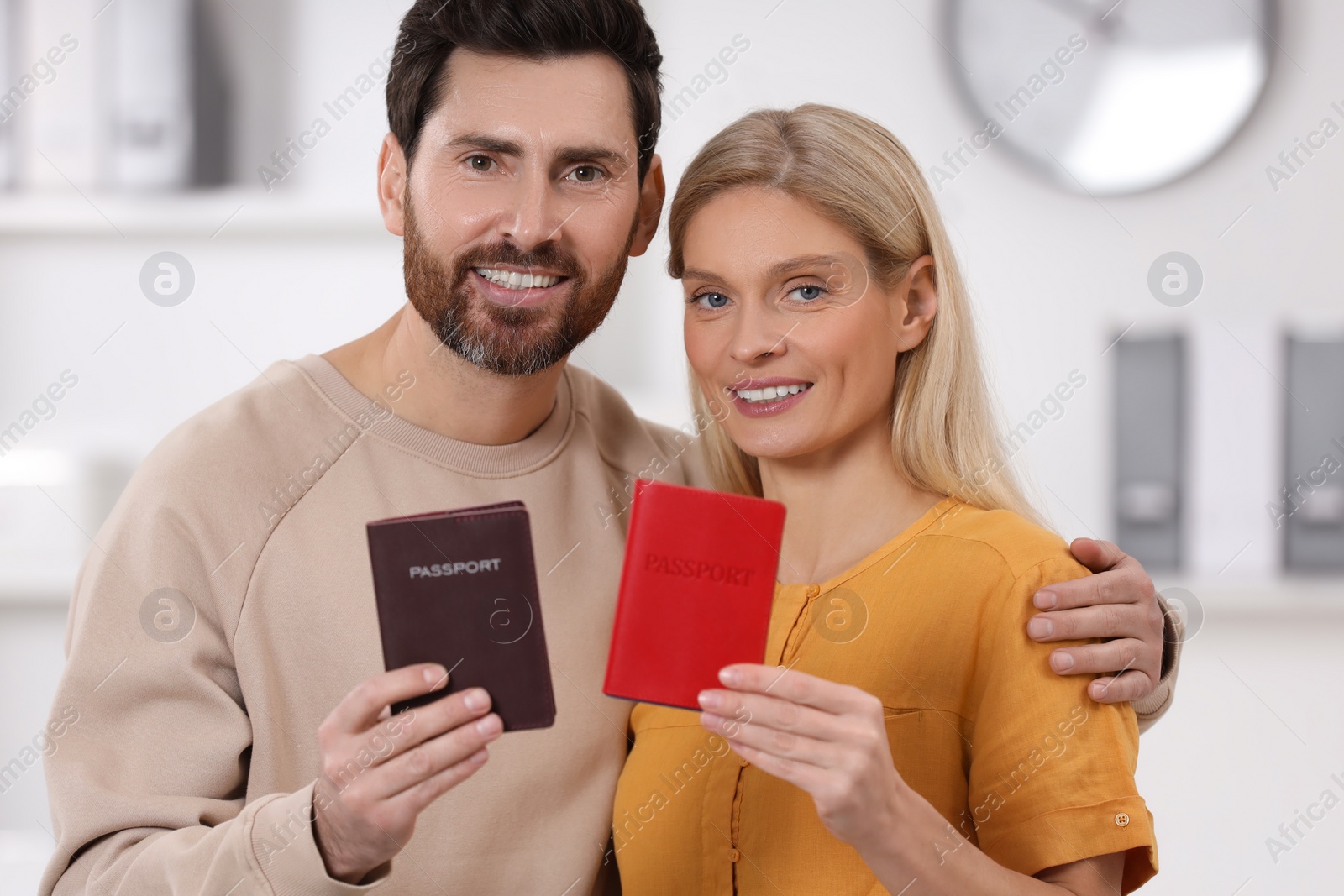 Photo of Immigration. Happy man and woman with passports indoors