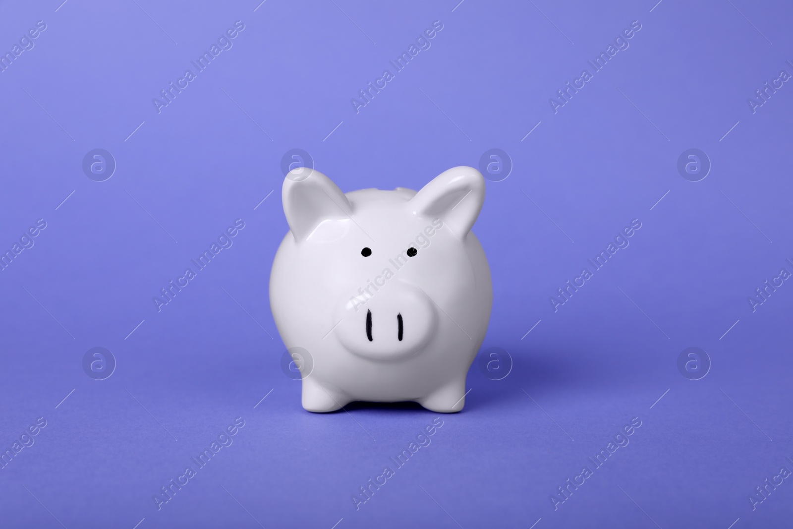 Photo of Ceramic piggy bank on purple background. Financial savings