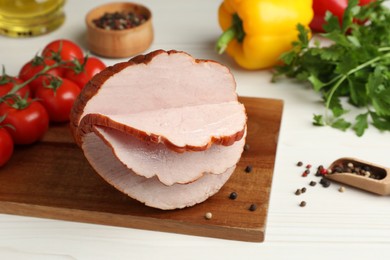 Photo of Delicious cut ham and vegetables on white wooden table