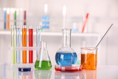 Laboratory analysis. Different glassware with liquids on white table against blurred background