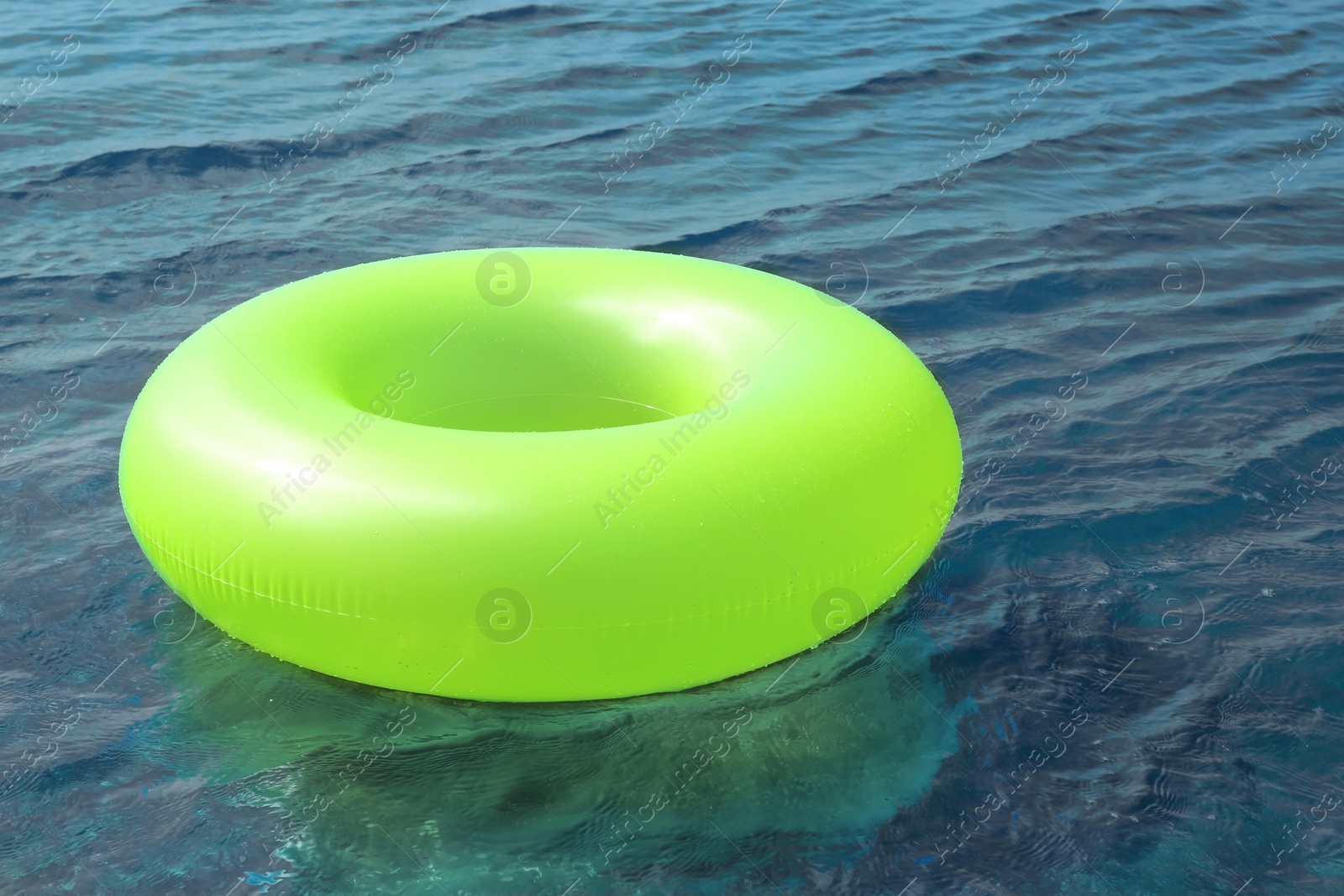 Photo of Bright inflatable ring floating on sea water. Summer vacation