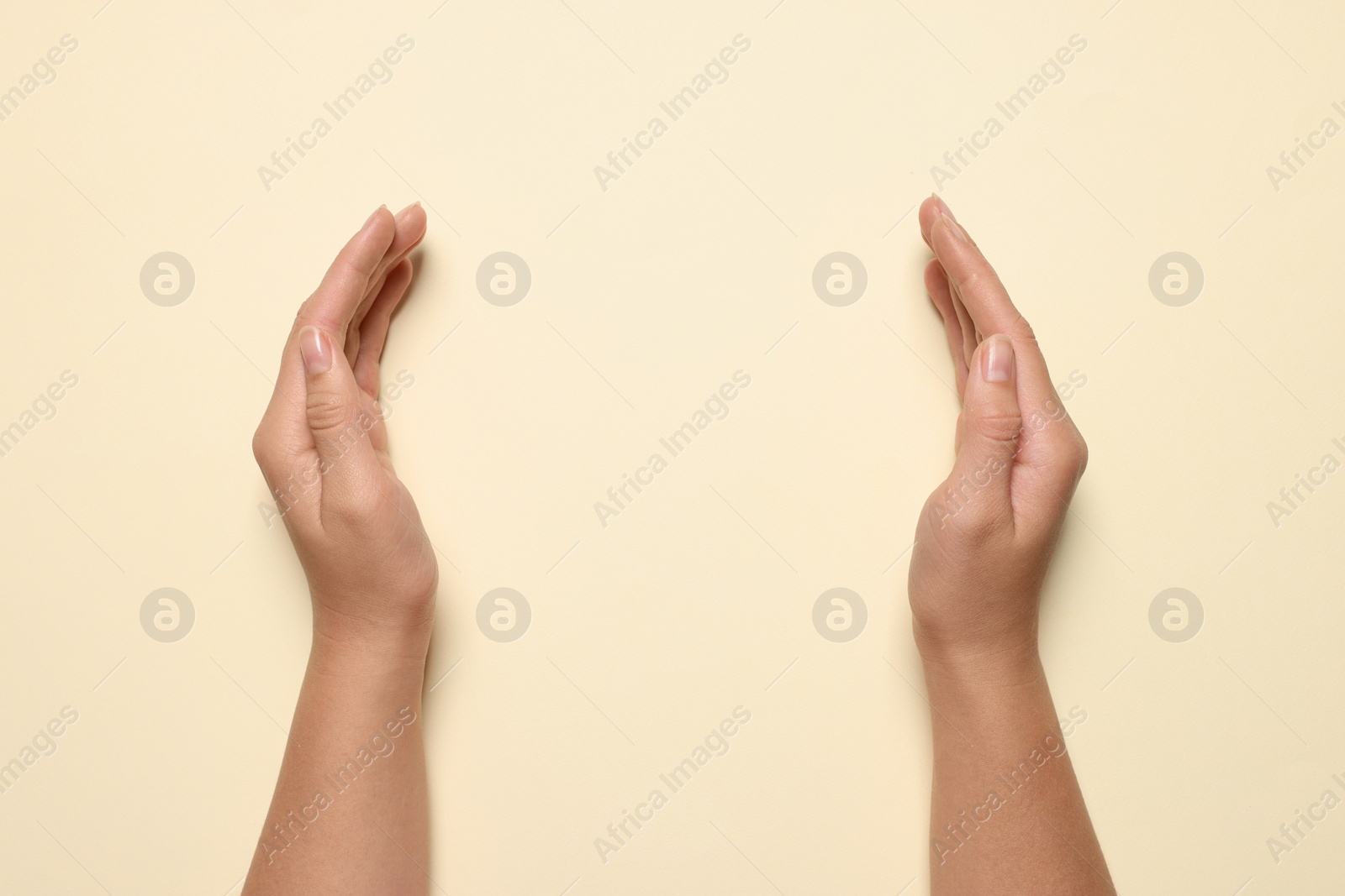 Photo of Woman holding on beige background, closeuphands. Space for text