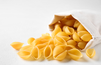 Uncooked conchiglie pasta on white table, closeup