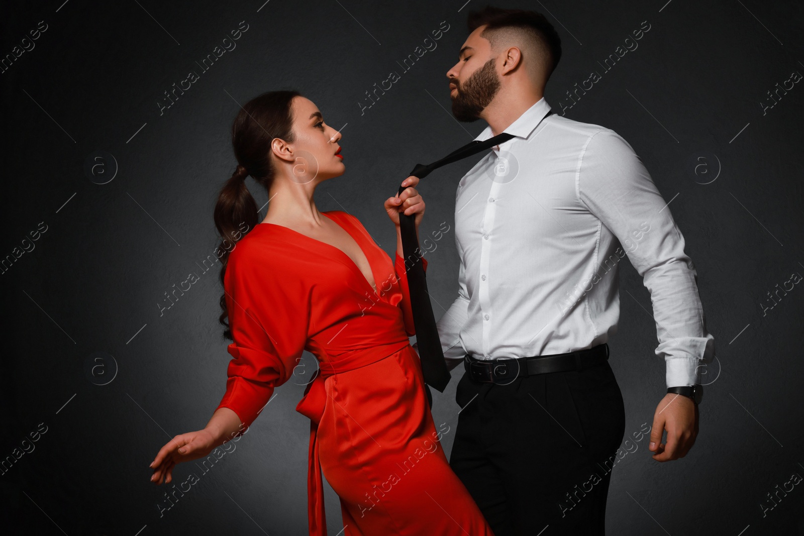 Photo of Handsome bearded man with sexy lady on dark background