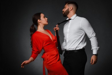 Handsome bearded man with sexy lady on dark background