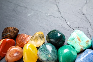 Photo of Different gemstones on grey table, closeup. Space for text
