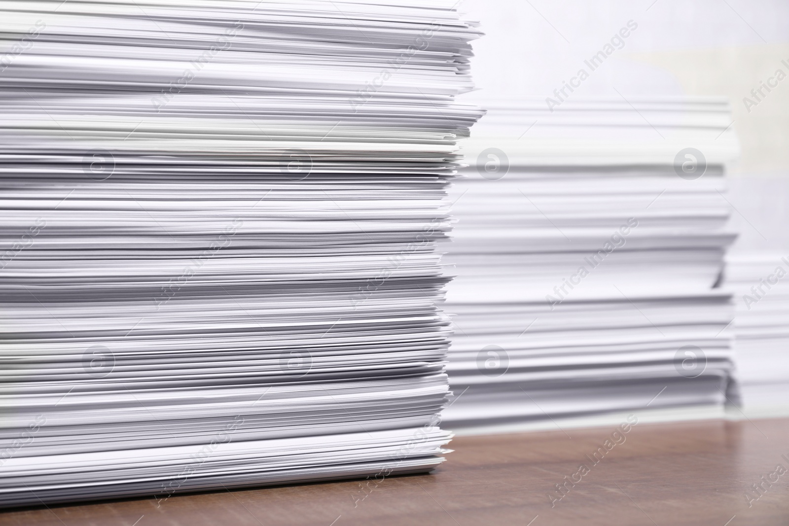 Photo of Stacks of white paper sheets on wooden table, space for text