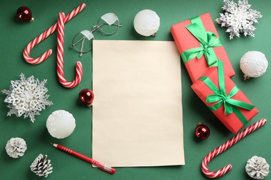 Photo of Flat lay composition with blank sheet of paper on green background, space for text. Writing letter to Santa
