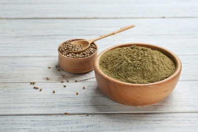 Photo of Bowls with hemp protein powder and seeds on table