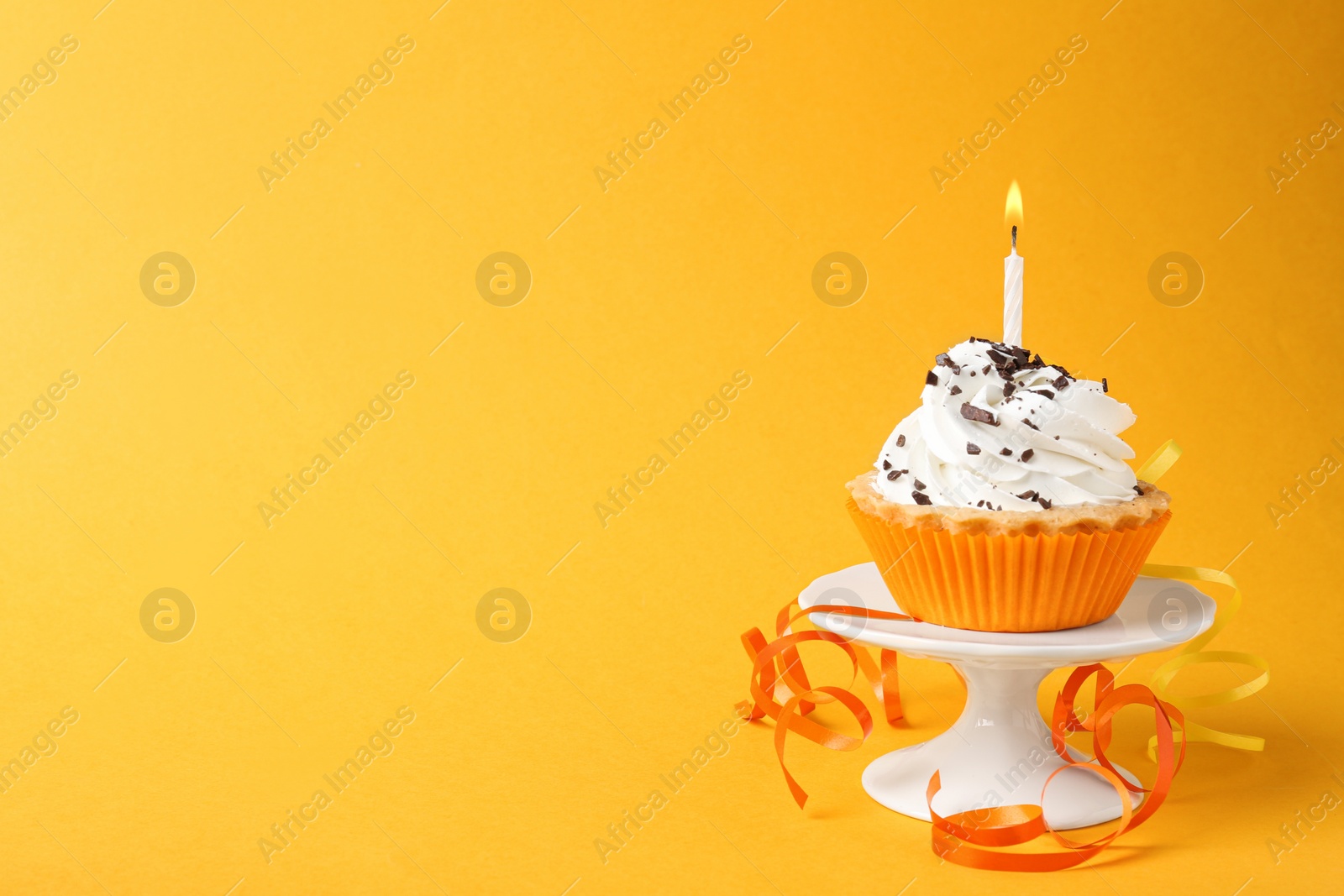 Photo of Delicious birthday cupcake with candle on yellow background. Space for text