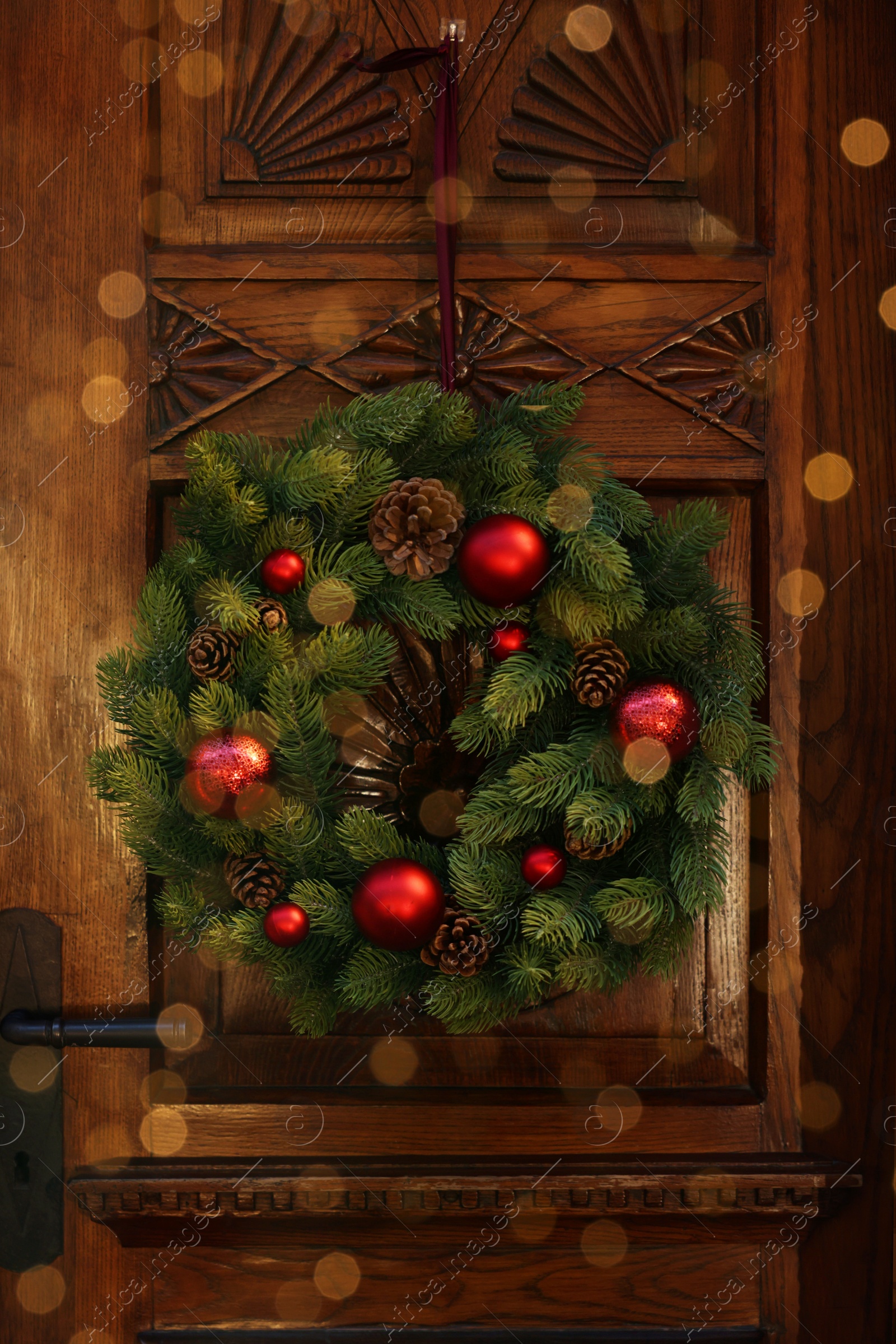 Photo of Beautiful Christmas wreath hanging on wooden door