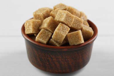 Photo of Brown sugar cubes on white table, closeup