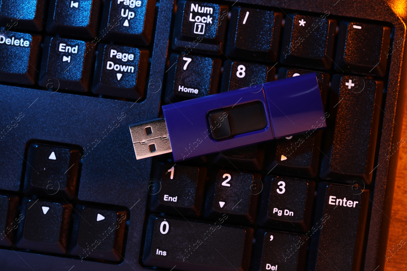 Photo of Modern usb flash drive on computer keyboard, top view