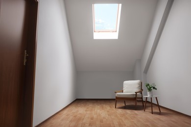 Attic spacious room interior with slanted ceiling and furniture