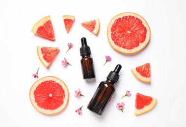 Photo of Flat lay composition with bottles of citrus essential oil on white background