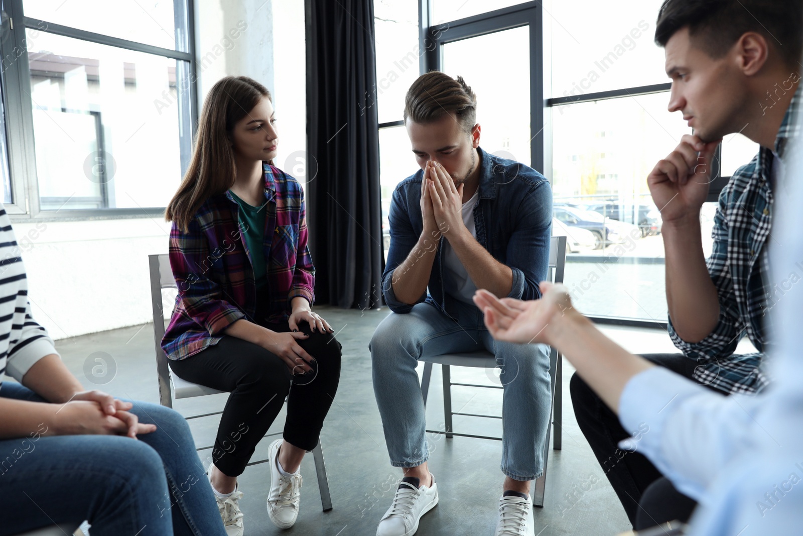 Photo of Psychotherapist working with patients in group therapy session indoors