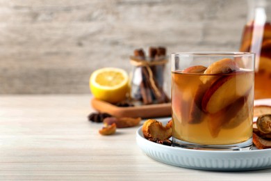 Delicious compot with dried apple slices on light wooden table. Space for text