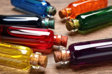 Photo of Bottles with different food coloring on wooden background, closeup