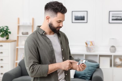 Photo of Diabetes test. Man using glucometer at home