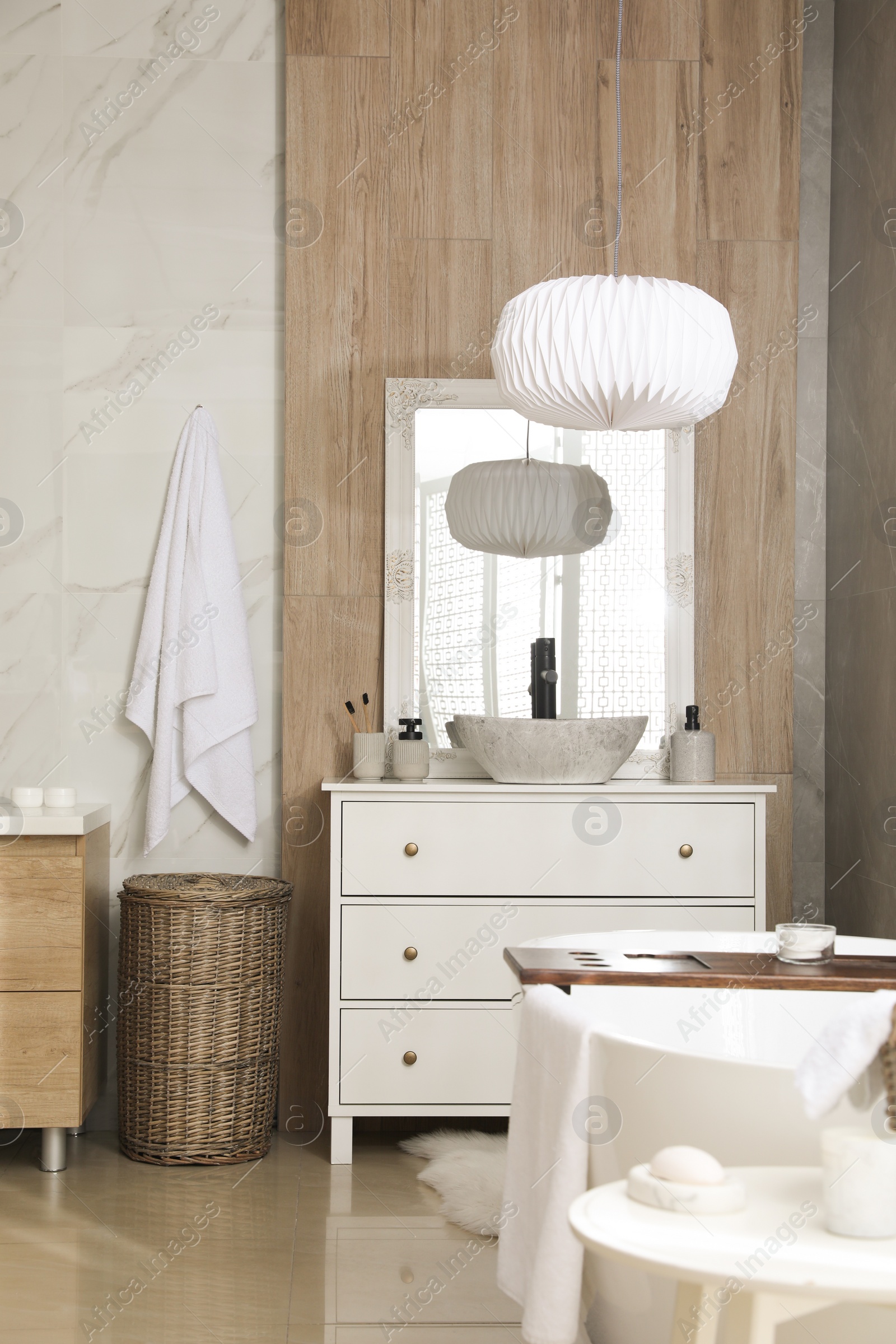 Photo of Modern white tub and chest of drawers with sink in bathroom. Interior design