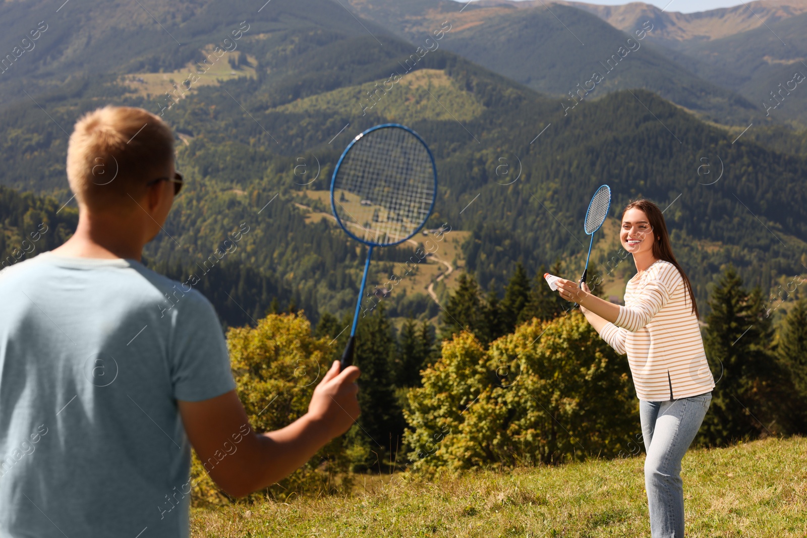 Photo of Couple playing badminton in mountains on sunny day