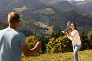 Couple playing badminton in mountains on sunny day