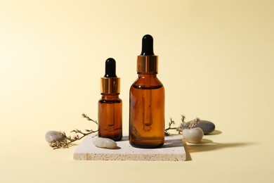 Photo of Composition with bottles of cosmetic serum on beige background