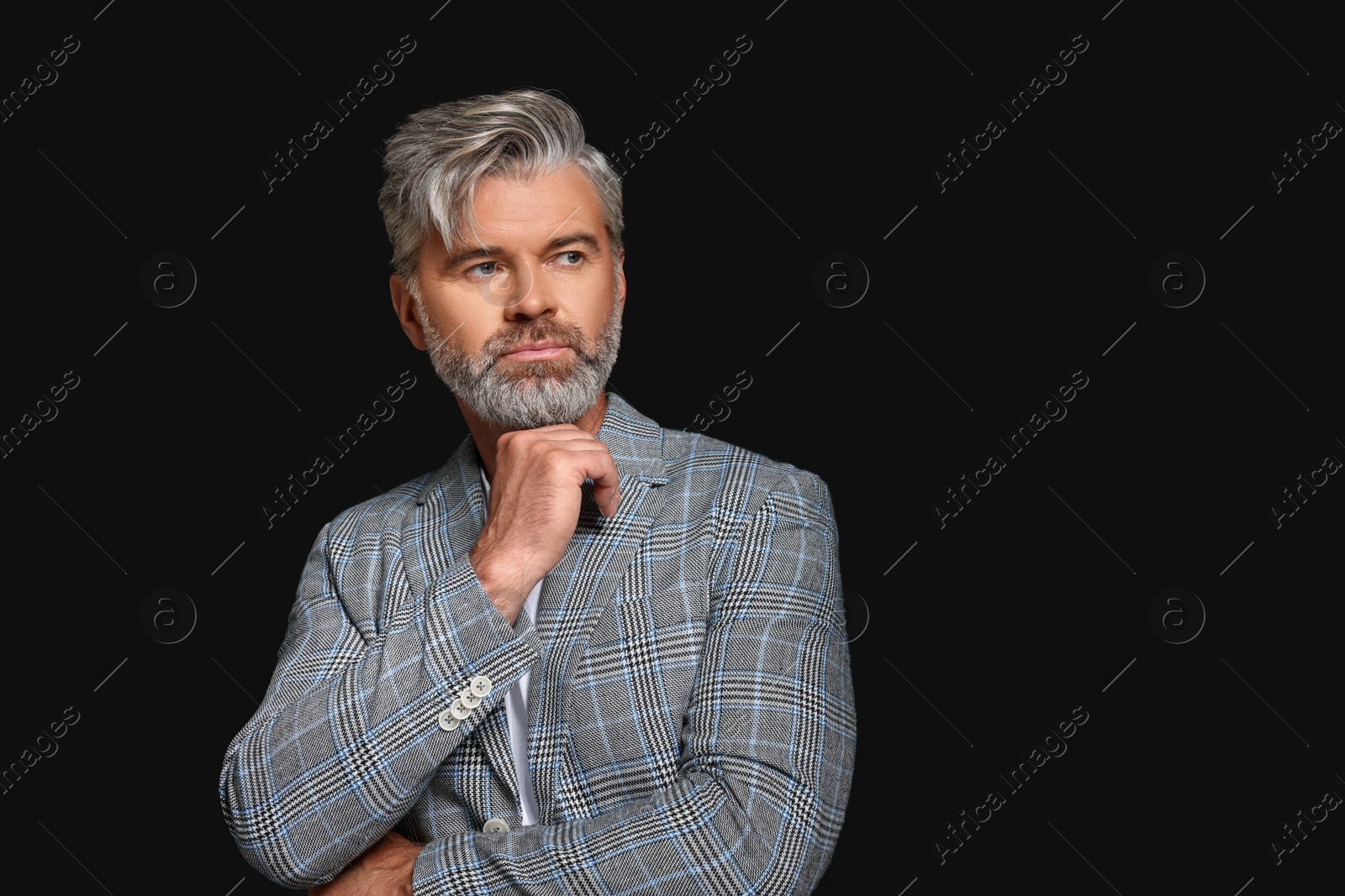 Photo of Portrait of confident man with beautiful hairstyle on black background. Space for text