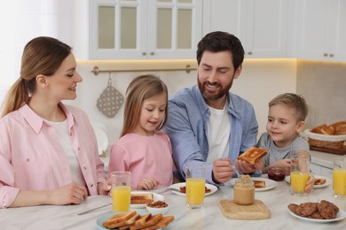 Happy family having breakfast at table in kitchen