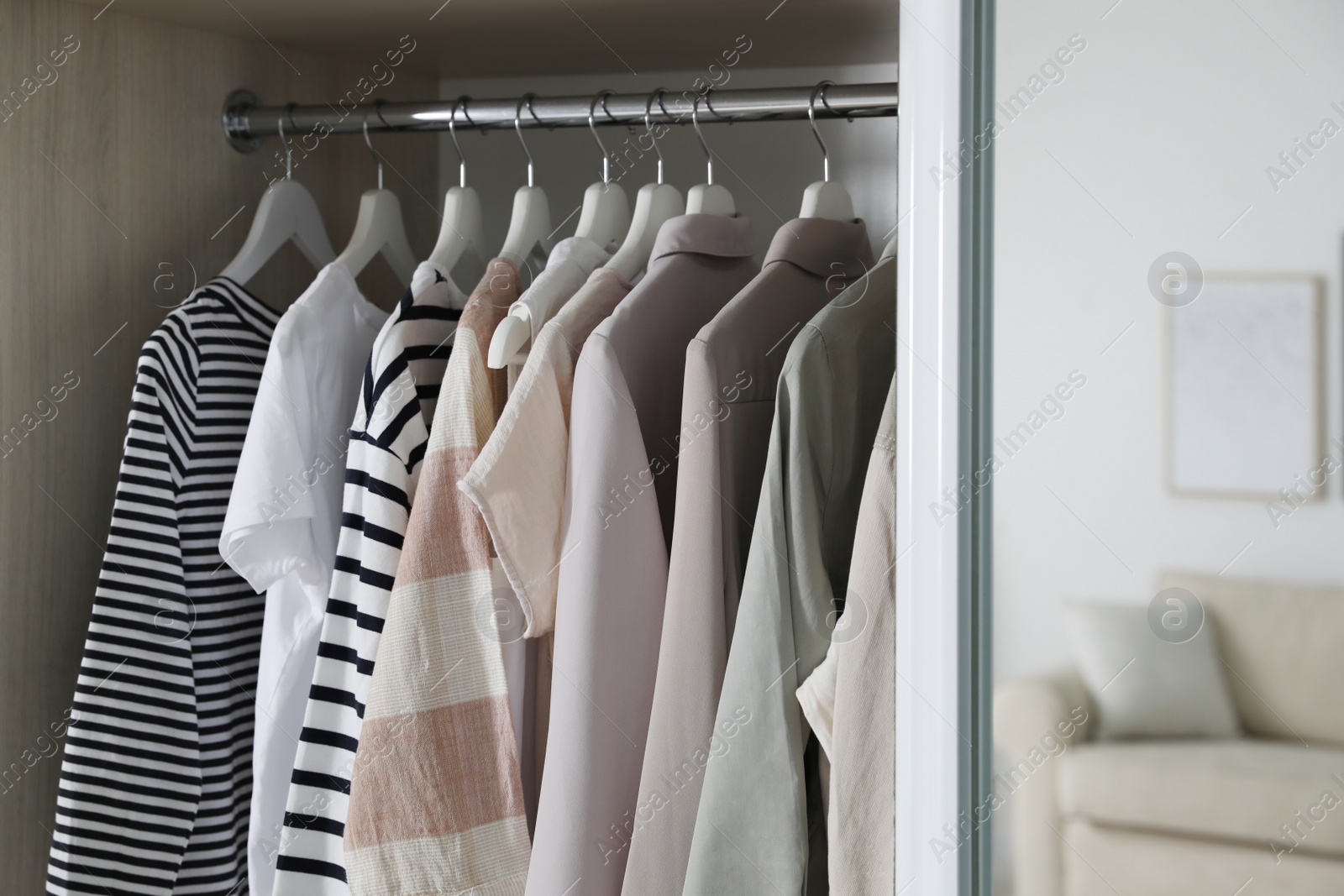 Photo of Wardrobe closet with different stylish clothes in room, closeup