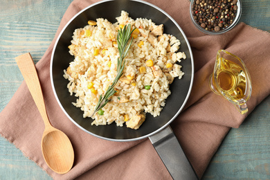 Photo of Delicious chicken risotto served on light blue wooden table, flat lay