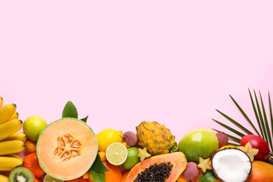 Photo of Different exotic fruits on light pink background, flat lay. Space for text