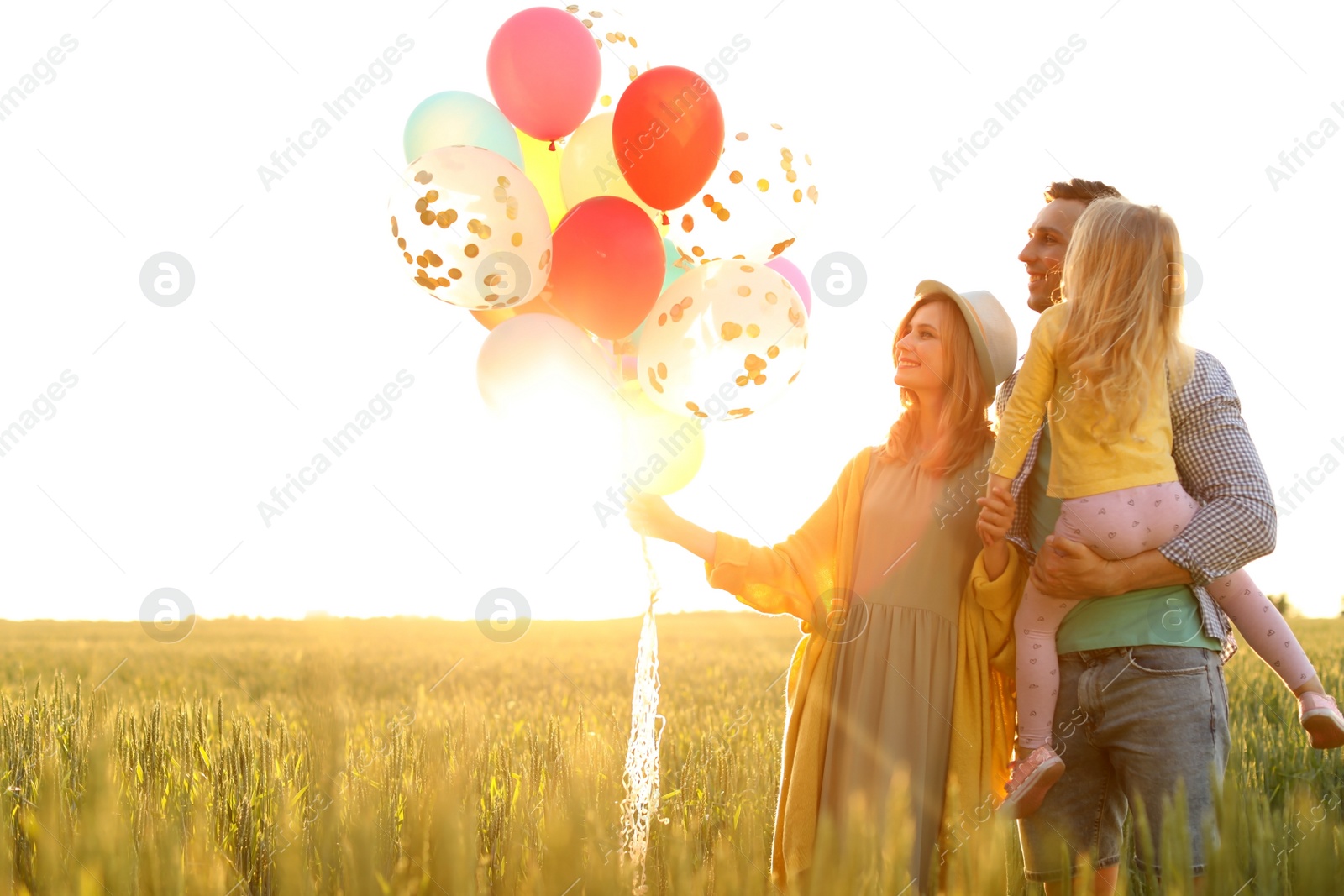 Photo of Happy family with colorful balloons outdoors on sunny day