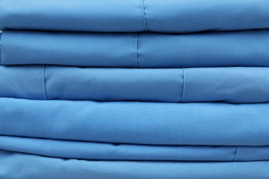 Photo of Light blue medical uniforms as background, closeup