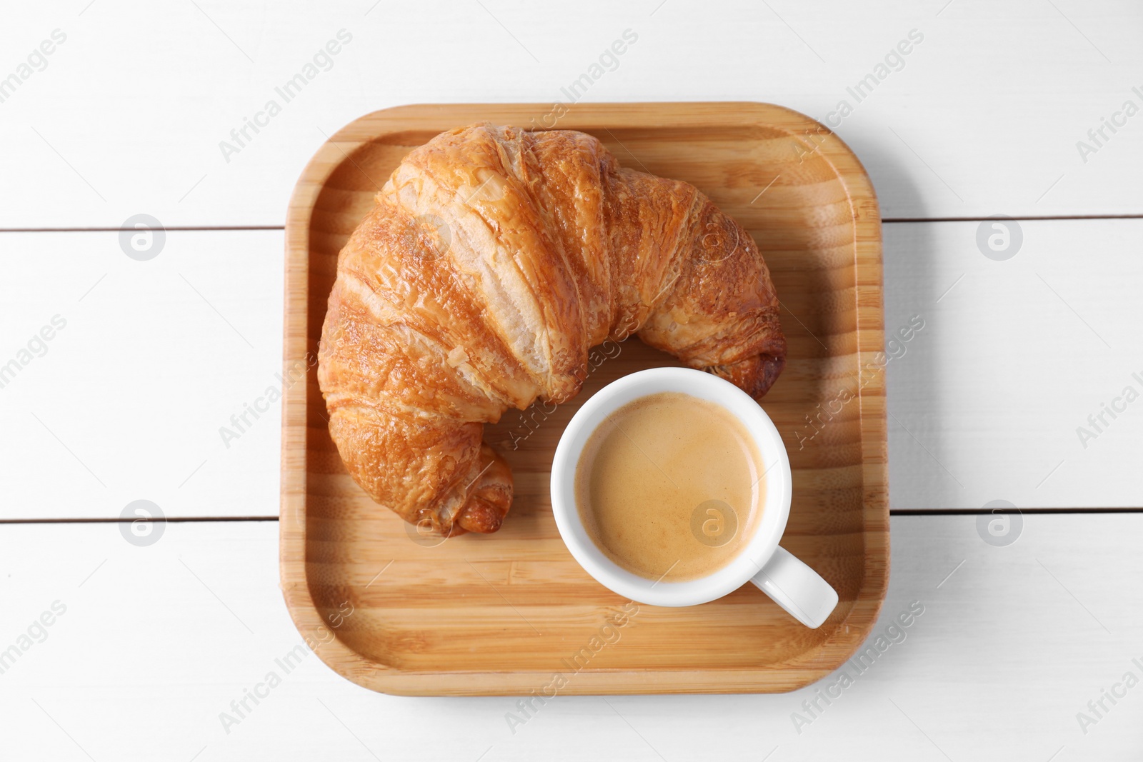 Photo of Fresh croissant and coffee on white wooden table, top view. Tasty breakfast