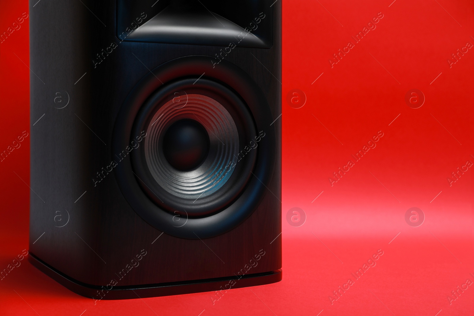 Photo of One wooden sound speaker on red background, closeup. Space for text