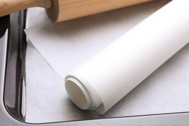 Photo of Parchment paper and rolling pin in baking pan, closeup