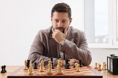 Photo of Man playing chess during tournament at table indoors