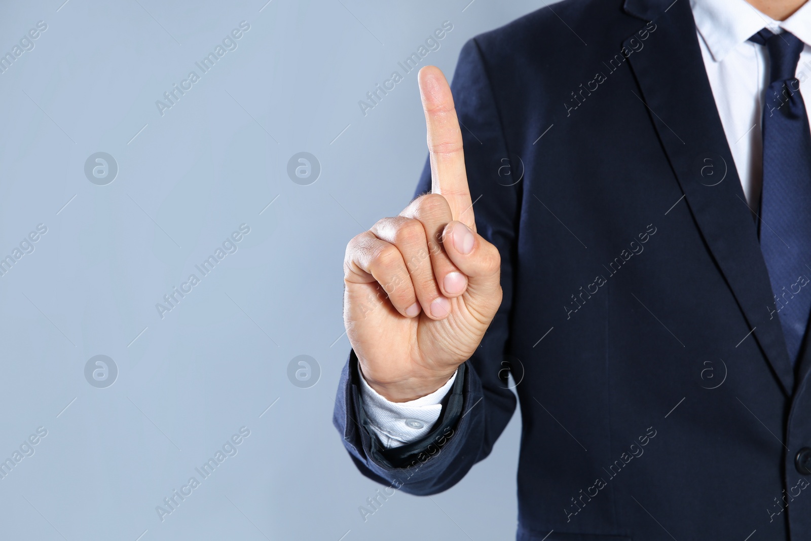 Photo of Businessman pointing on grey background, closeup view of hand with space for text