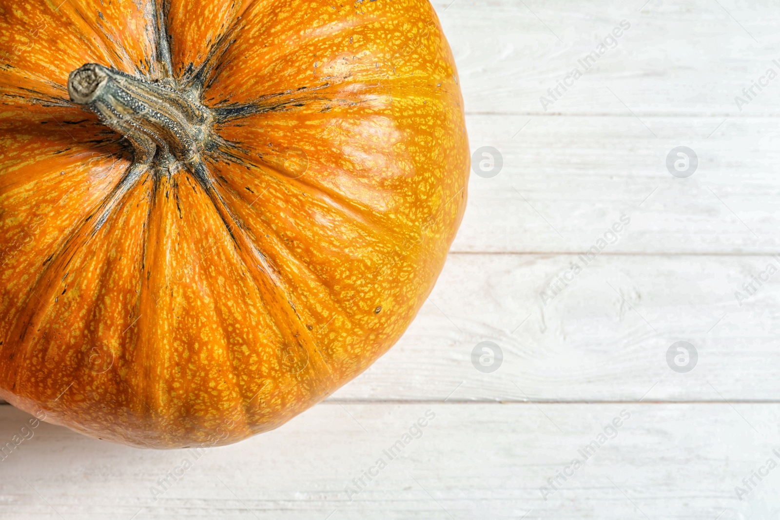 Photo of Orange pumpkin and space for text on light wooden background, top view. Autumn holidays