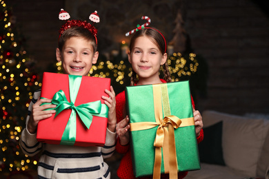 Portrait of happy children with Christmas gifts at home