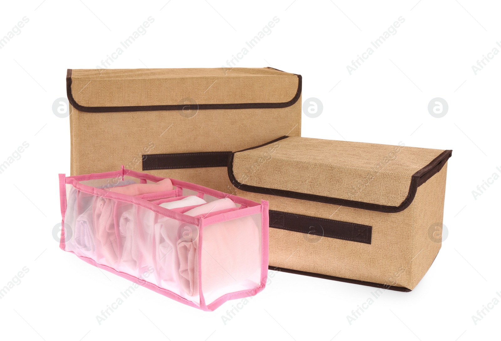 Photo of Textile storage cases and organizer with clothes on white background