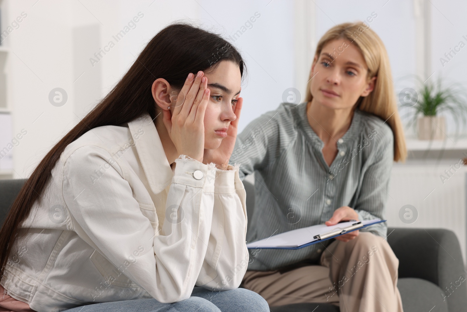 Photo of Psychologist working with teenage girl in office. Teenager problems